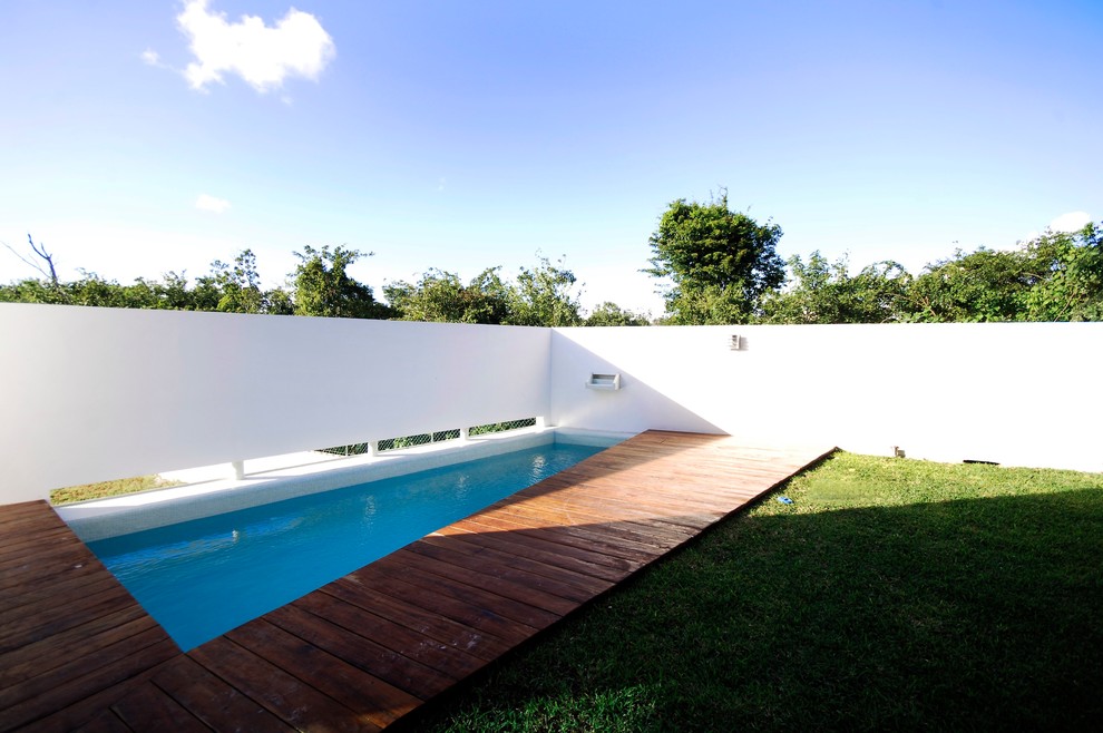 Aménagement d'une piscine moderne rectangle avec une terrasse en bois.