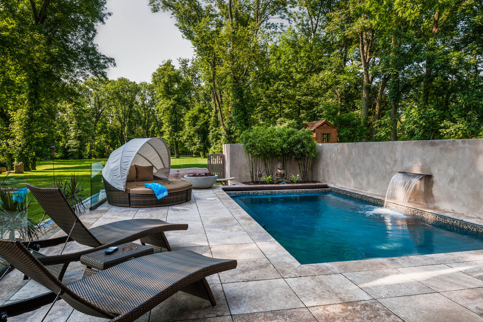 Ispirazione per una grande piscina contemporanea rettangolare dietro casa con pavimentazioni in pietra naturale