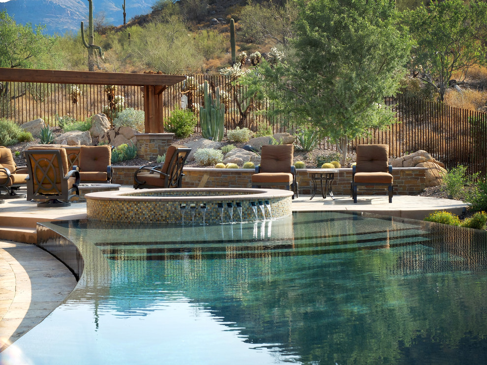 Idée de décoration pour une très grande piscine à débordement et arrière sud-ouest américain sur mesure avec un bain bouillonnant et des pavés en pierre naturelle.