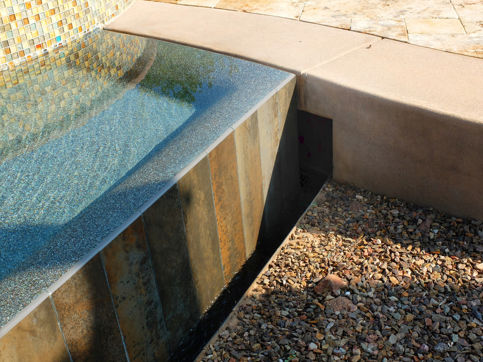 Пример оригинального дизайна: огромный бассейн-инфинити произвольной формы на заднем дворе в стиле фьюжн с джакузи и покрытием из каменной брусчатки