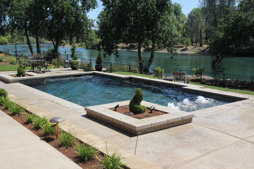 Foto di una piscina fuori terra minimal rettangolare di medie dimensioni e dietro casa con fontane e lastre di cemento