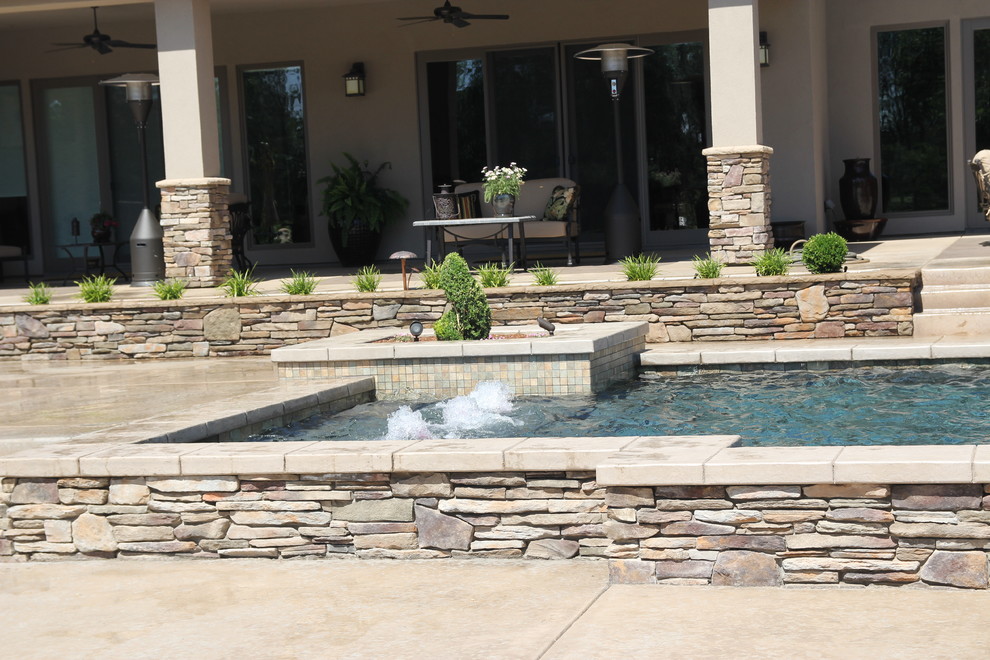 Example of a mid-sized trendy backyard concrete and rectangular aboveground pool fountain design in Other