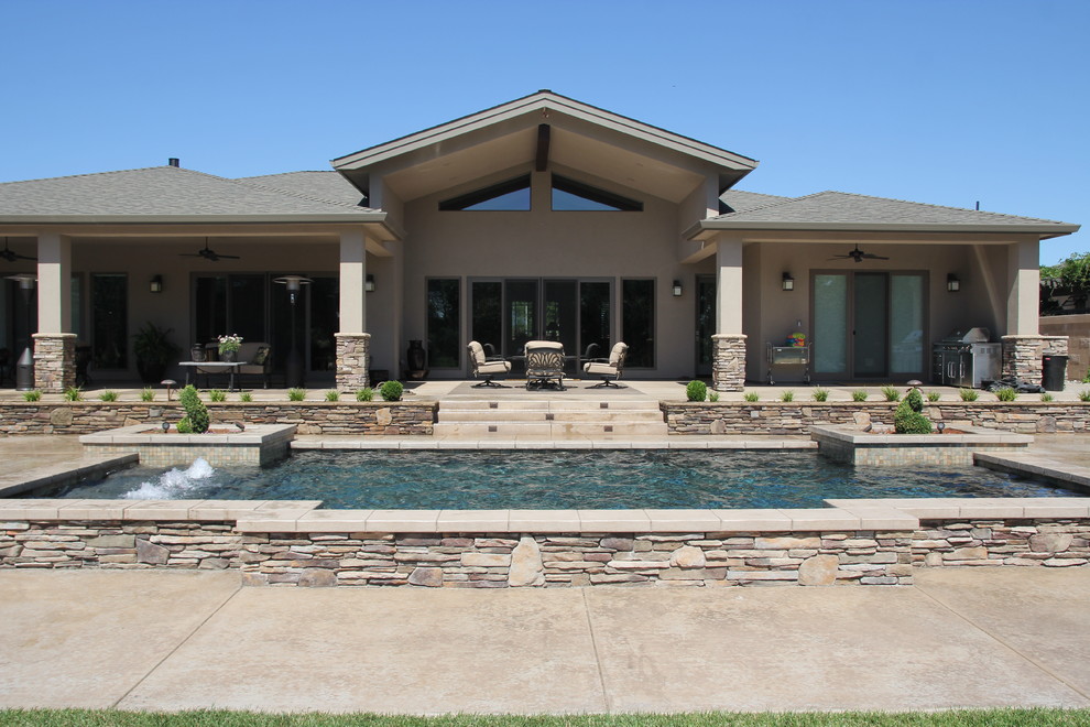 Foto de piscina con fuente elevada actual de tamaño medio rectangular en patio trasero con losas de hormigón