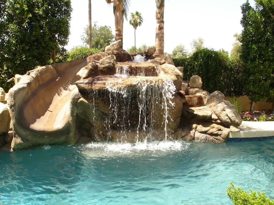 Imagen de piscina con tobogán de estilo americano de tamaño medio rectangular en patio trasero