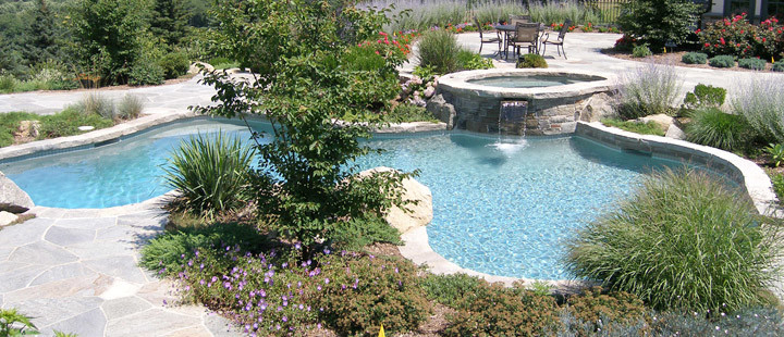Exemple d'une grande piscine arrière moderne sur mesure avec un bain bouillonnant et du béton estampé.