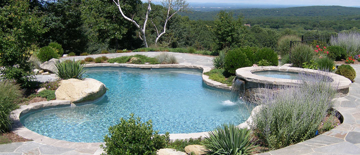 На фото: большой бассейн произвольной формы на заднем дворе в стиле модернизм с джакузи и покрытием из декоративного бетона с