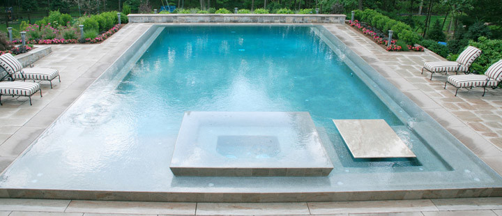 На фото: большой бассейн произвольной формы на заднем дворе в стиле модернизм с джакузи и покрытием из декоративного бетона с