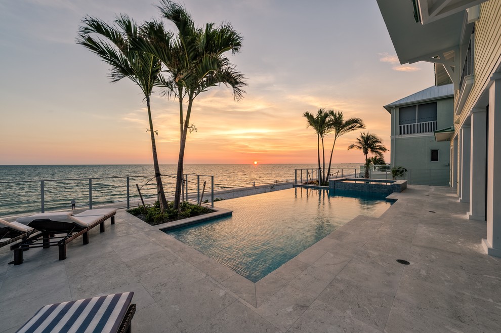 Geräumiger Maritimer Infinity-Pool hinter dem Haus in rechteckiger Form mit Wasserspiel und Natursteinplatten in Miami