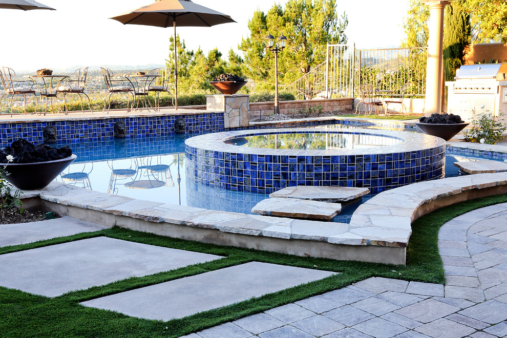 Идея дизайна: естественный бассейн произвольной формы, среднего размера на заднем дворе в стиле неоклассика (современная классика) с джакузи и покрытием из каменной брусчатки
