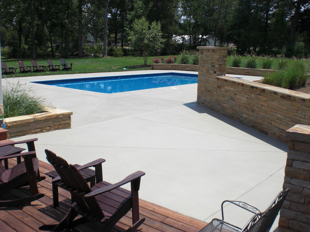 Exemple d'une piscine arrière chic rectangle avec une dalle de béton.