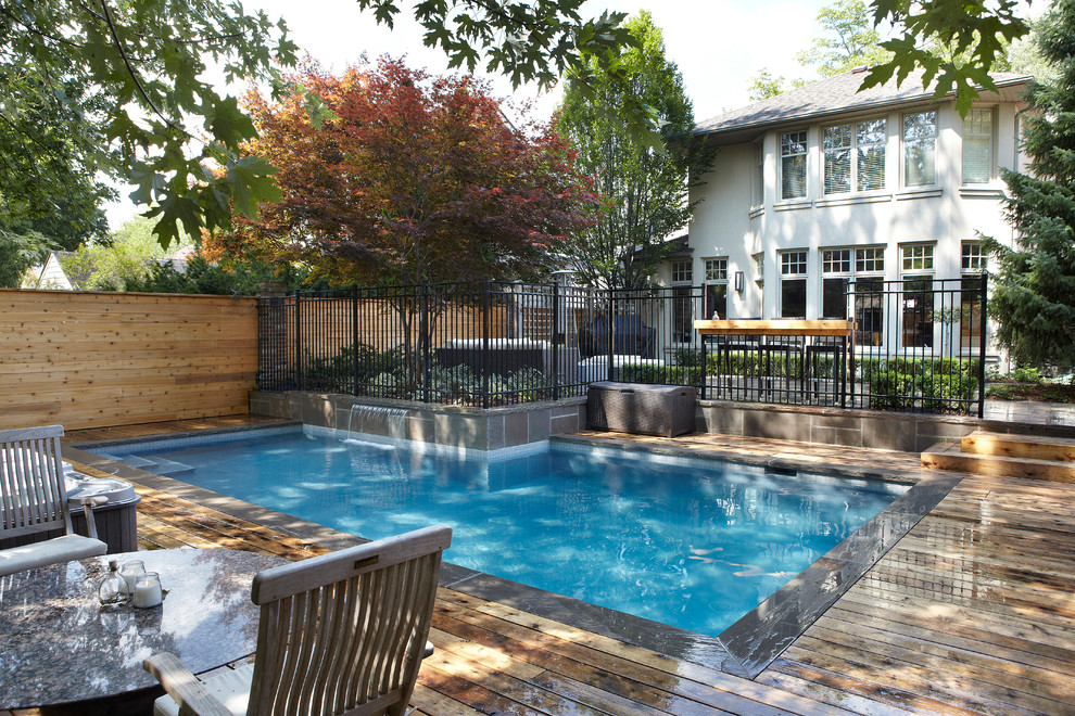 Mid-sized trendy backyard concrete paver and rectangular lap hot tub photo in Toronto