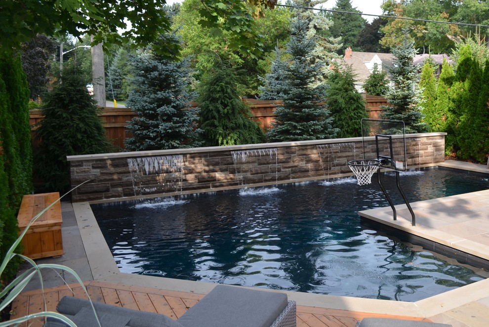 Diseño de piscina con fuente tradicional renovada de tamaño medio a medida con adoquines de piedra natural