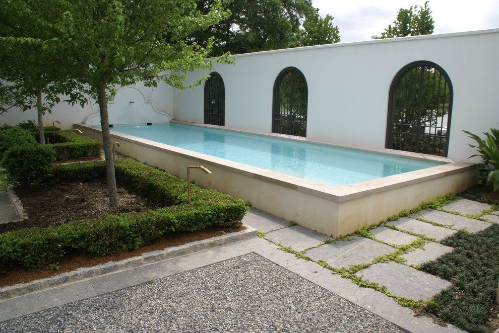 На фото: большой наземный, прямоугольный бассейн на внутреннем дворе в стиле модернизм с фонтаном и мощением тротуарной плиткой с