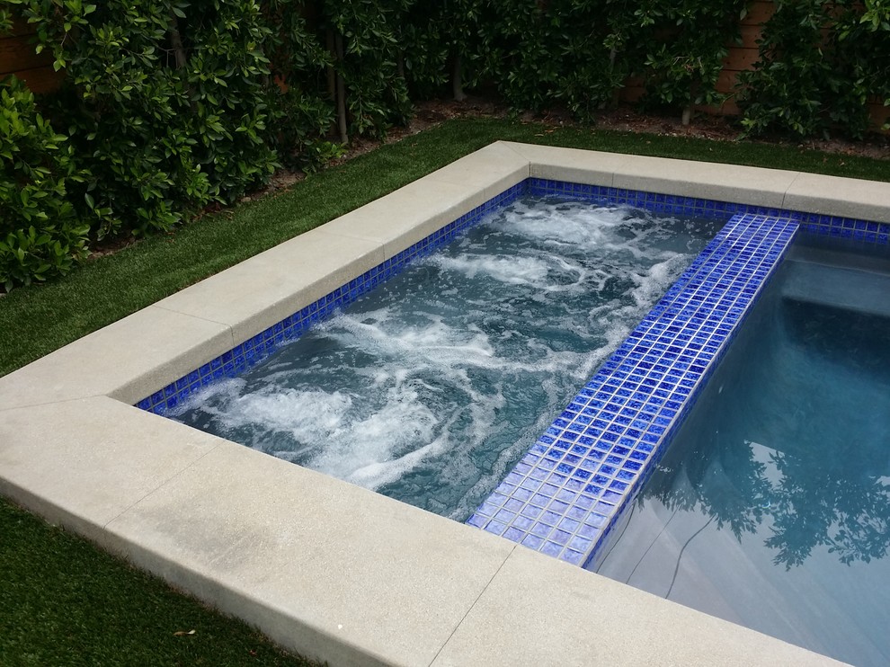 Design ideas for a small modern back rectangular natural hot tub in Los Angeles with concrete paving.