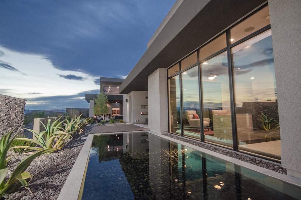 Immagine di una piccola piscina a sfioro infinito minimal personalizzata dietro casa con lastre di cemento