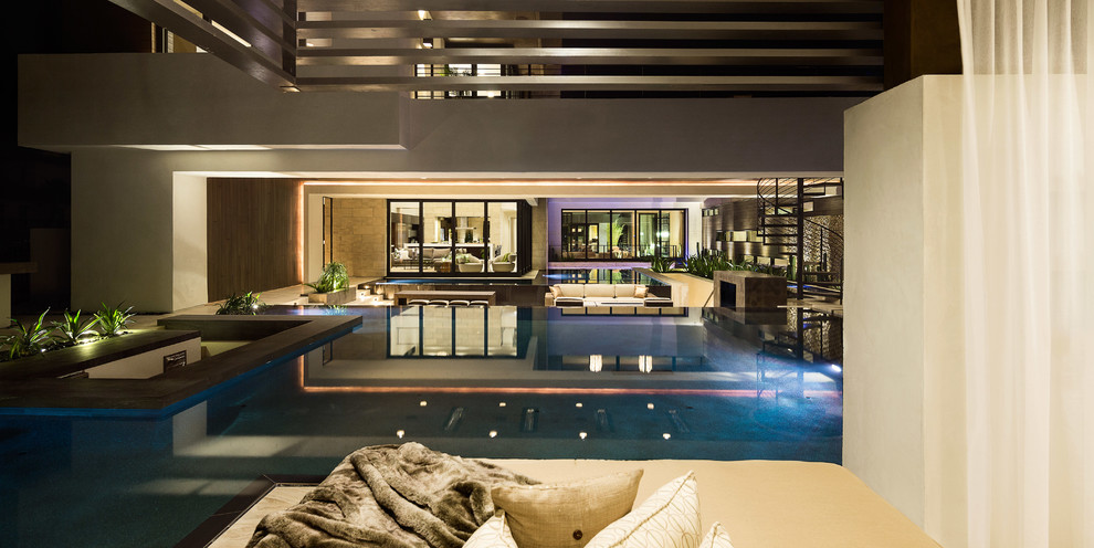 Inspiration for an expansive contemporary back custom shaped infinity swimming pool in Las Vegas with concrete slabs.