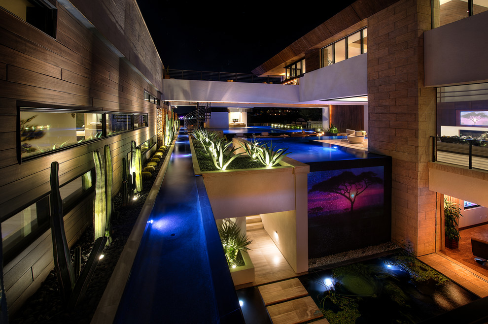 Стильный дизайн: огромный бассейн-инфинити произвольной формы на внутреннем дворе в современном стиле с покрытием из бетонных плит - последний тренд