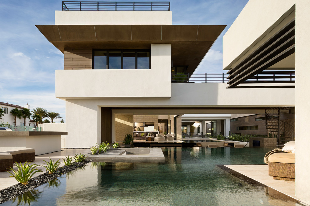 Ispirazione per un'ampia piscina a sfioro infinito minimal personalizzata dietro casa con lastre di cemento