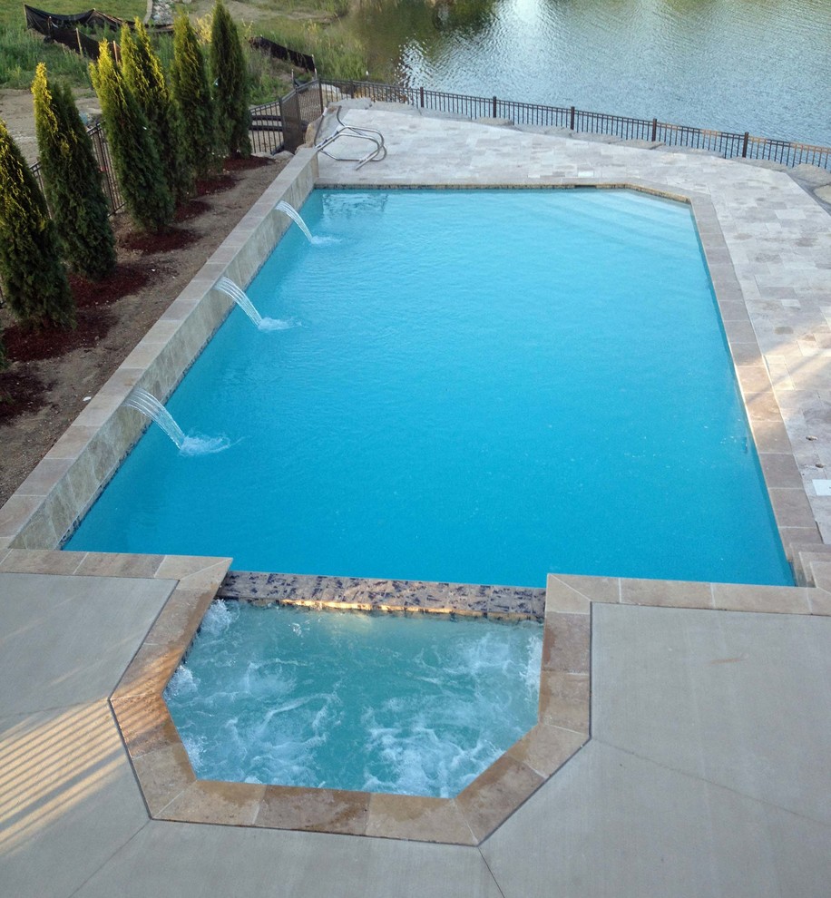 Modelo de piscinas y jacuzzis alargados actuales grandes rectangulares en patio trasero con suelo de baldosas