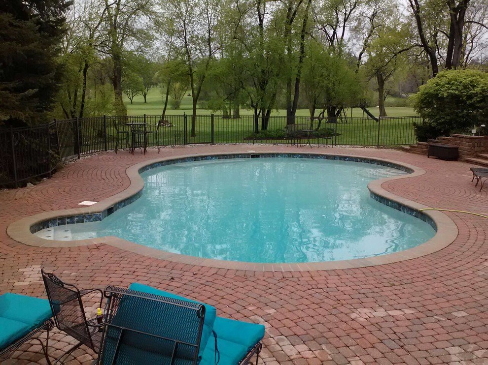 Foto di una piscina monocorsia classica a "C" dietro casa e di medie dimensioni con pavimentazioni in cemento