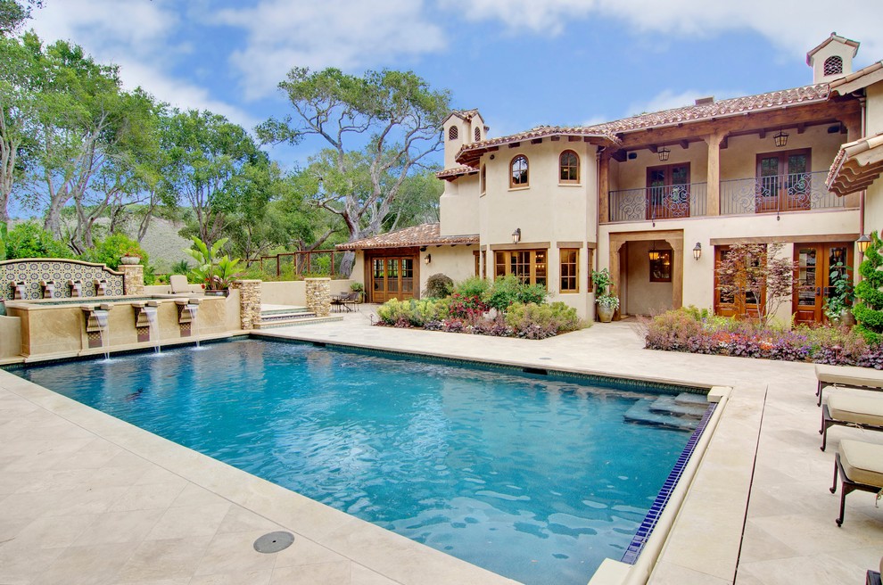 Modelo de piscina con fuente alargada mediterránea grande rectangular en patio con adoquines de piedra natural