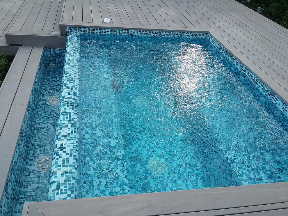Esempio di una piccola piscina a sfioro infinito minimal personalizzata dietro casa con una vasca idromassaggio e piastrelle