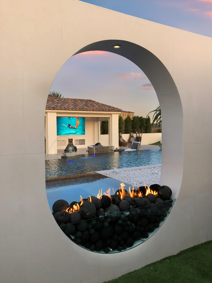 Design ideas for a medium sized modern back custom shaped infinity hot tub in Orange County.