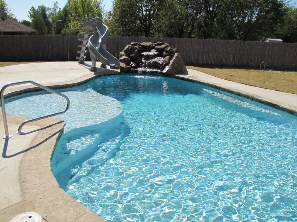 Ejemplo de piscina natural de estilo americano de tamaño medio a medida en patio trasero