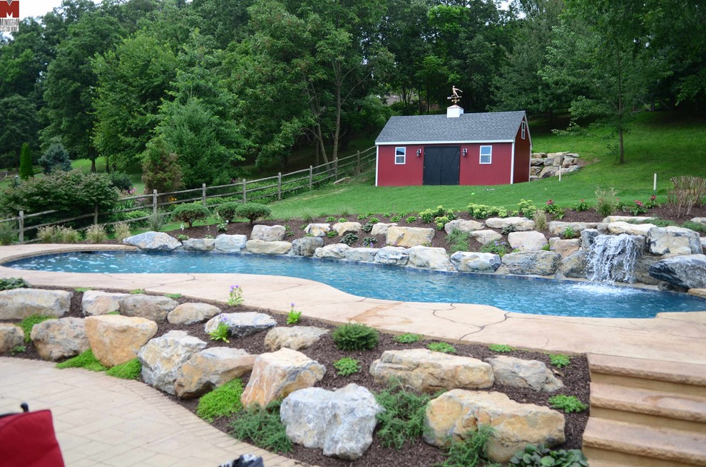 Foto på en stor funkis pool på baksidan av huset, med en fontän och stämplad betong