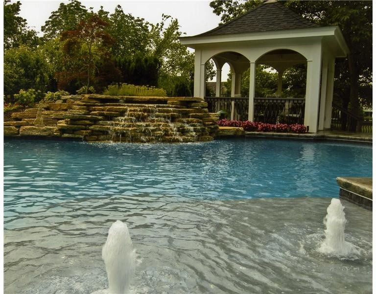 Inspiration for a mid-sized backyard stamped concrete and custom-shaped natural pool remodel in Cincinnati