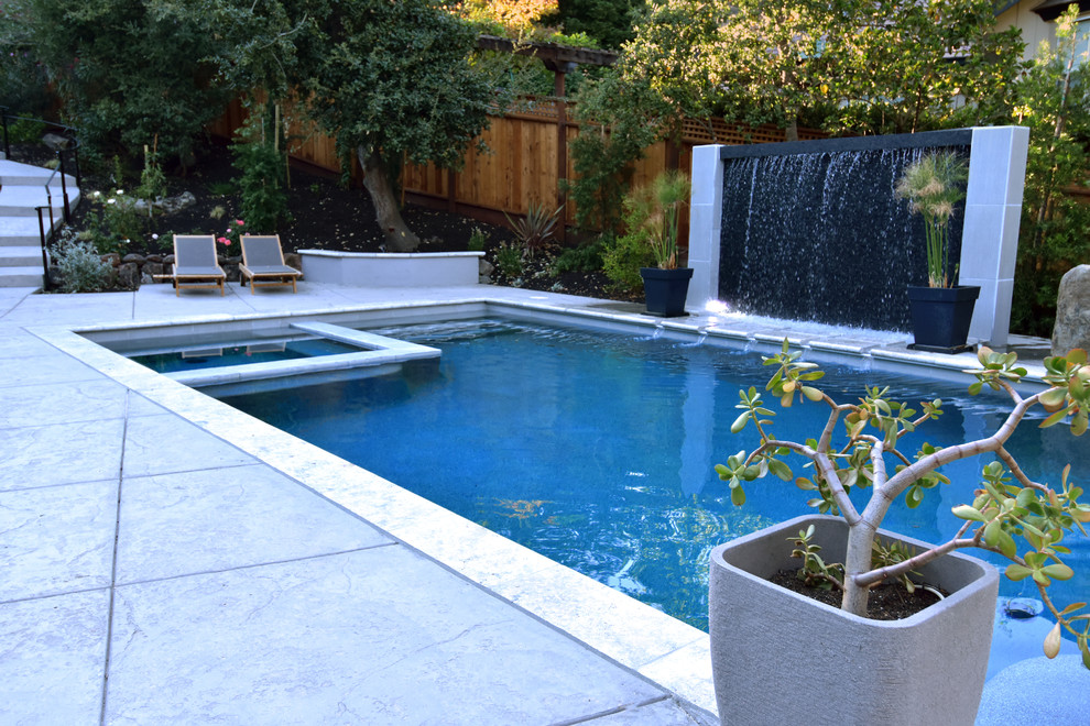 Свежая идея для дизайна: большой наземный, прямоугольный бассейн на заднем дворе в стиле кантри с фонтаном и покрытием из бетонных плит - отличное фото интерьера