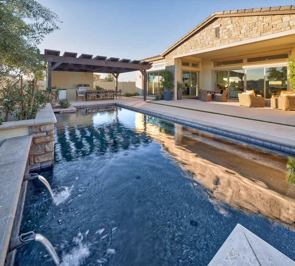 Diseño de piscina natural contemporánea grande rectangular en patio trasero con adoquines de hormigón