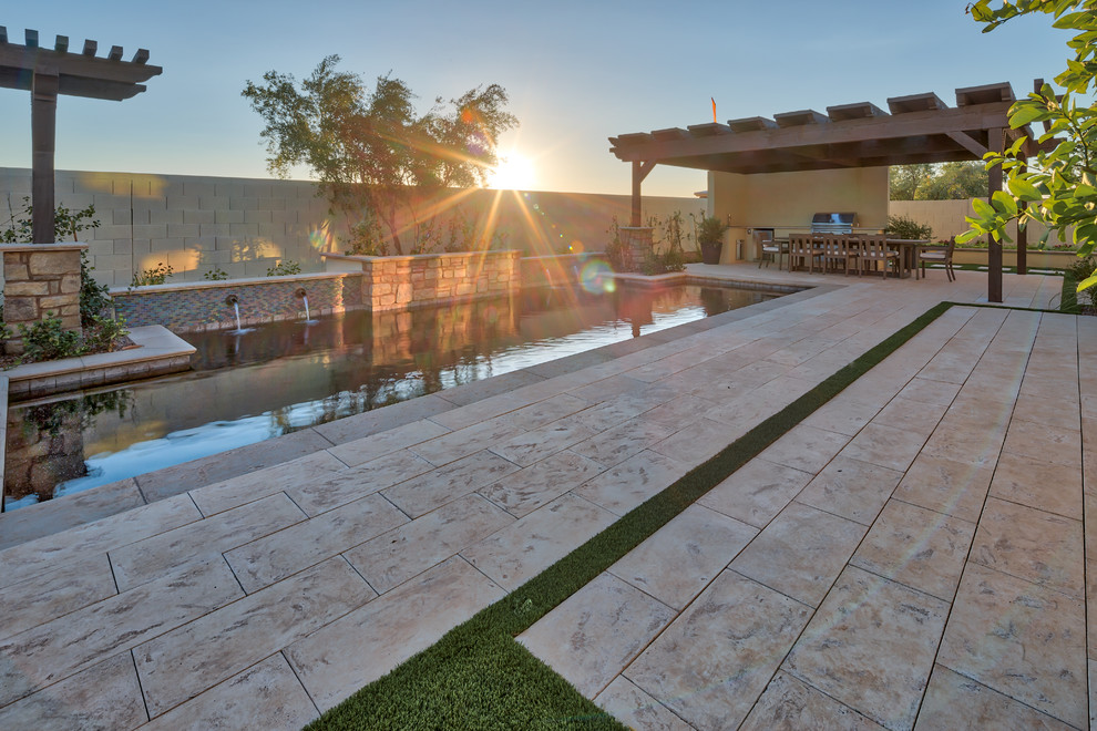 Immagine di una grande piscina naturale design rettangolare dietro casa con pavimentazioni in cemento