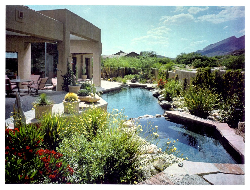 Idée de décoration pour une piscine arrière design de taille moyenne et sur mesure avec un bain bouillonnant et des pavés en pierre naturelle.