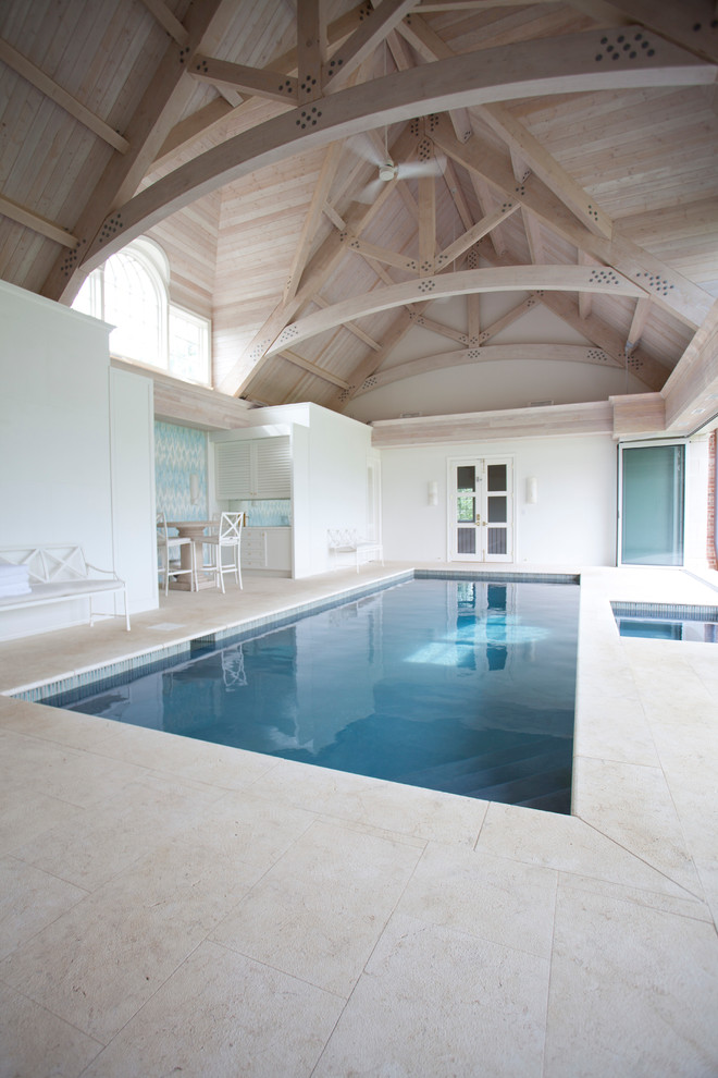 Esempio di un'ampia piscina coperta minimalista personalizzata con una dépendance a bordo piscina e pavimentazioni in pietra naturale
