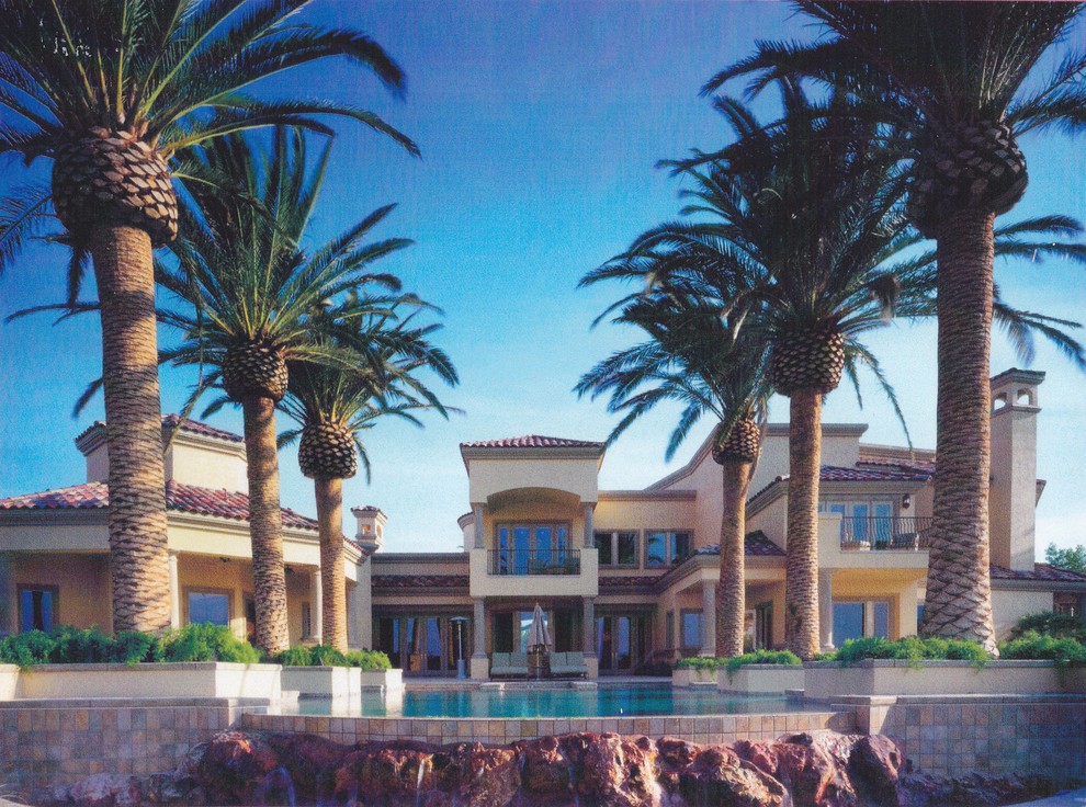 На фото: большой бассейн-инфинити произвольной формы на заднем дворе в средиземноморском стиле с фонтаном и покрытием из плитки