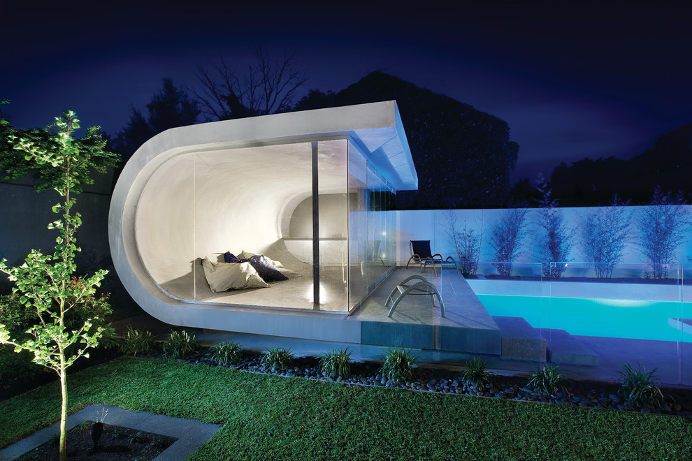 Ejemplo de casa de la piscina y piscina contemporánea grande rectangular en patio trasero