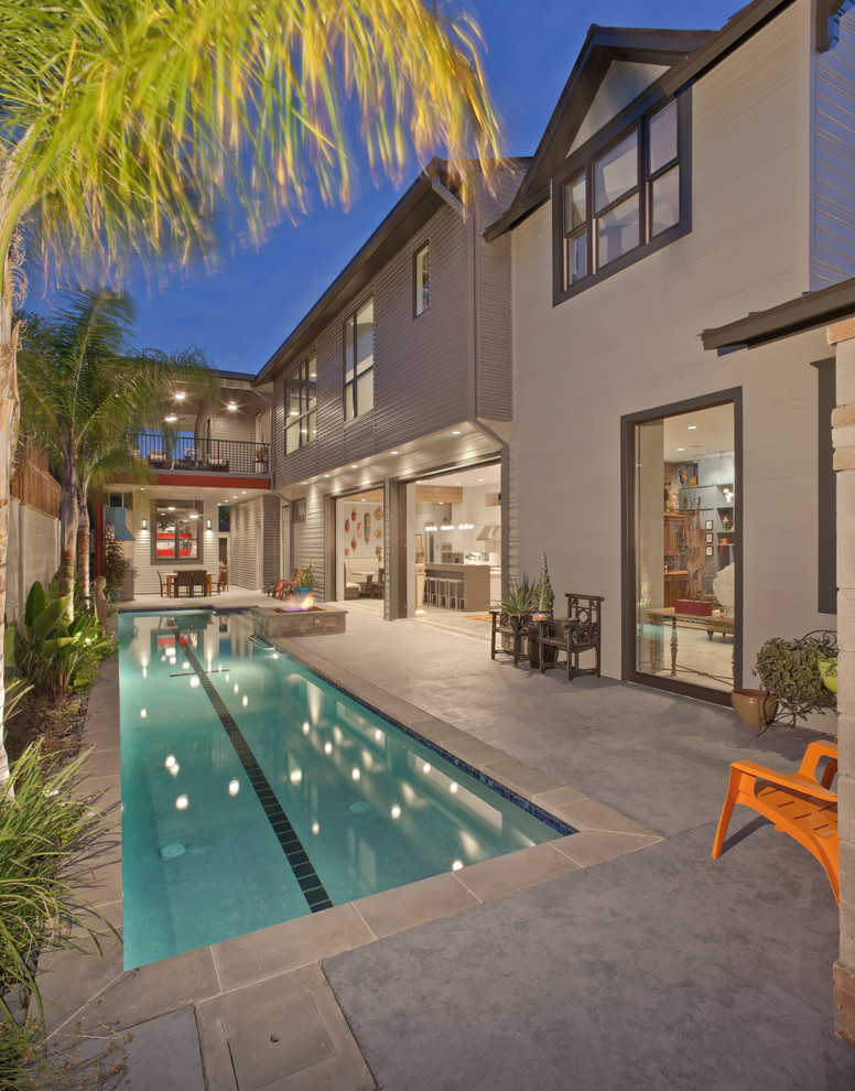 Imagen de piscina alargada contemporánea grande rectangular en patio trasero con losas de hormigón