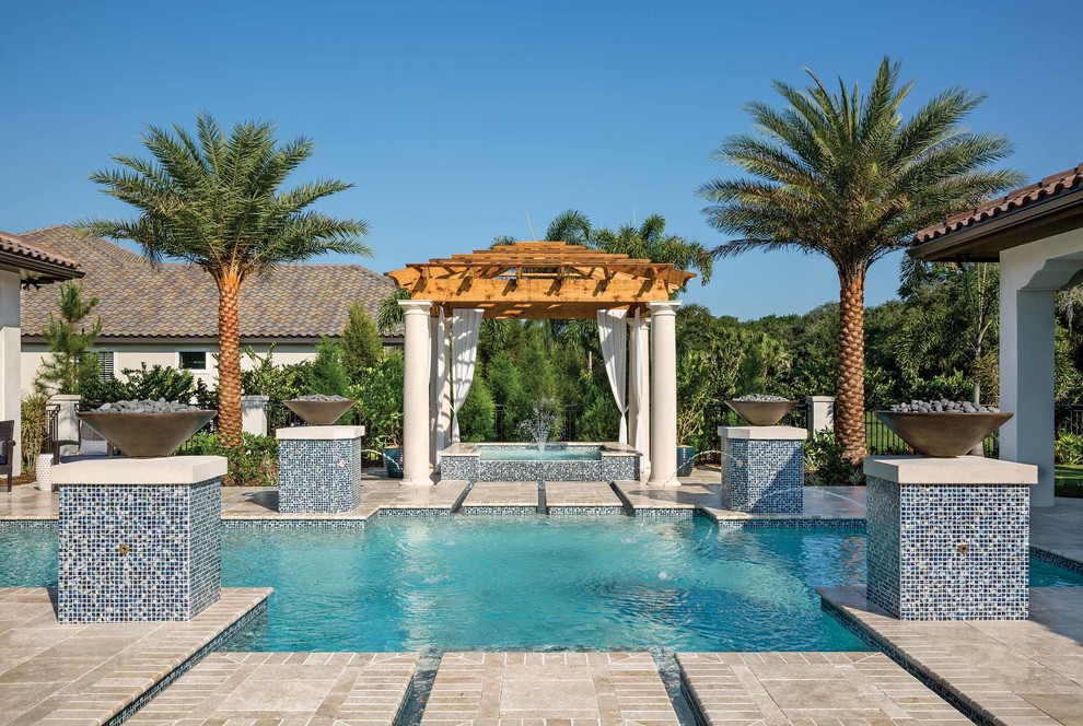 Modelo de piscina con fuente mediterránea de tamaño medio a medida en patio trasero con adoquines de piedra natural
