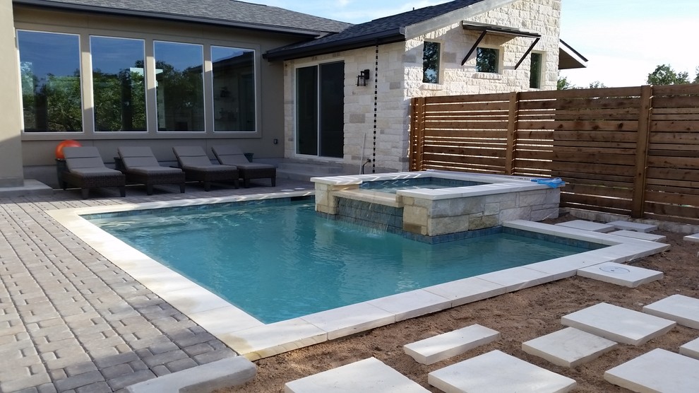 Imagen de piscinas y jacuzzis actuales de tamaño medio rectangulares en patio trasero con adoquines de hormigón