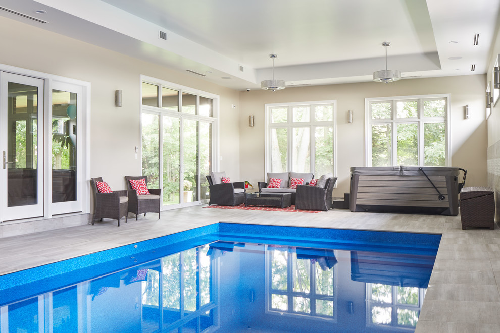 Inspiration för en stor funkis inomhus, rektangulär pool, med poolhus och naturstensplattor