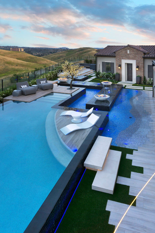 Mid-sized minimalist backyard custom-shaped infinity hot tub photo in Orange County