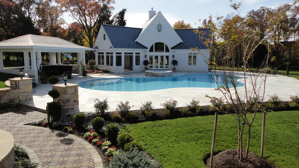 This is an example of a large classic back kidney-shaped lengths swimming pool in DC Metro with a pool house and stamped concrete.