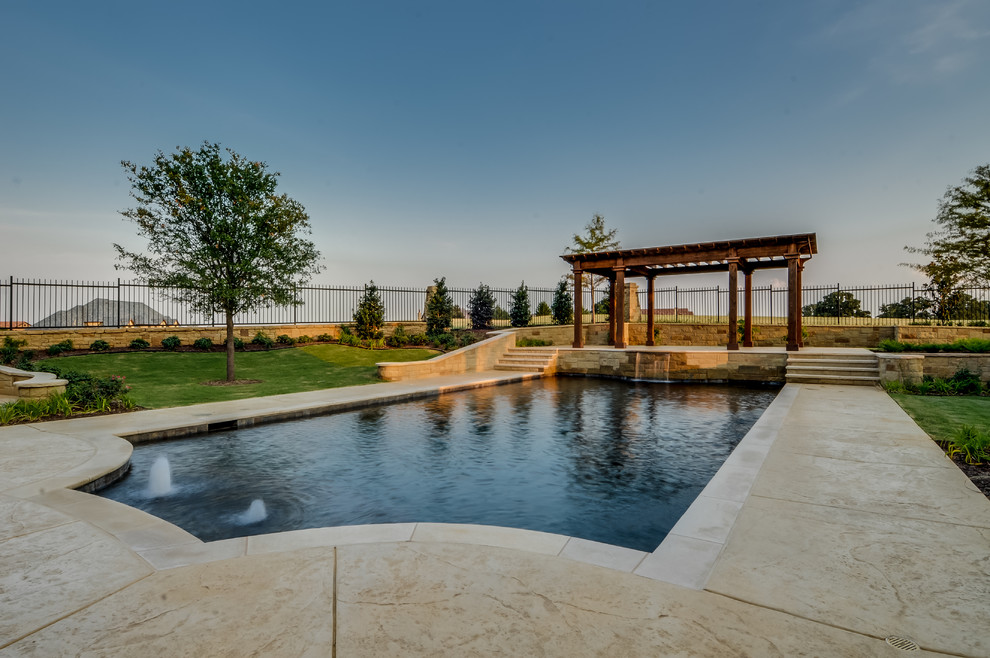 Ejemplo de piscina con fuente alargada mediterránea extra grande rectangular en patio trasero con adoquines de piedra natural