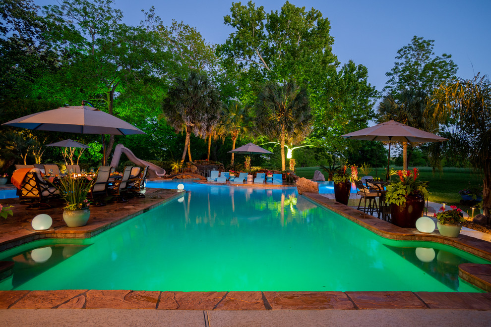 Ejemplo de casa de la piscina y piscina exótica extra grande a medida en patio trasero con suelo de baldosas