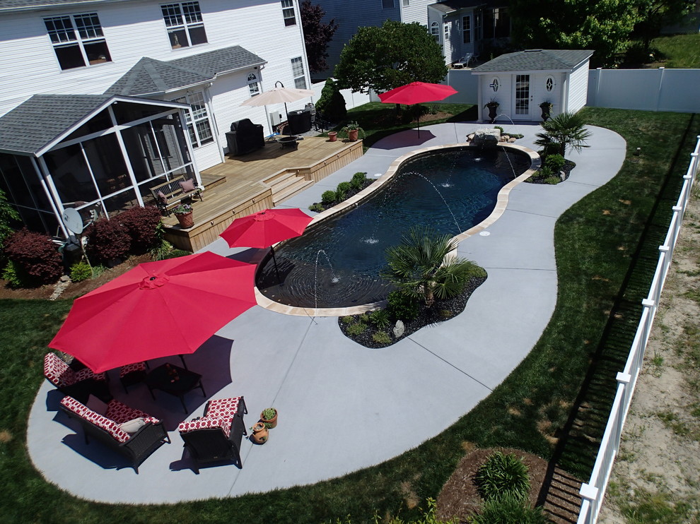На фото: большой бассейн произвольной формы на заднем дворе в современном стиле с