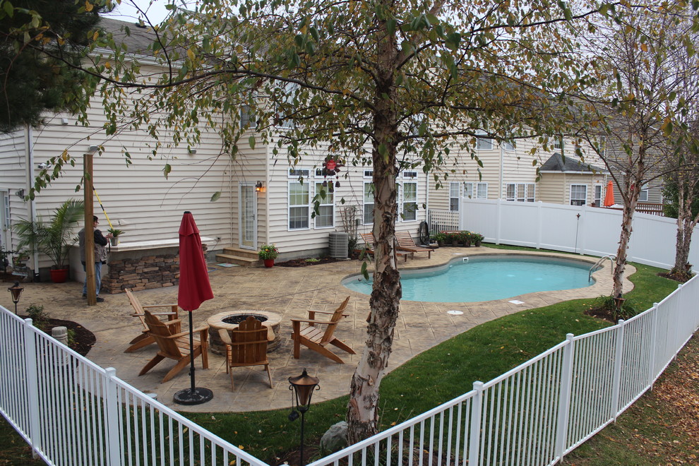 Foto di una piscina tropicale personalizzata di medie dimensioni e dietro casa con cemento stampato
