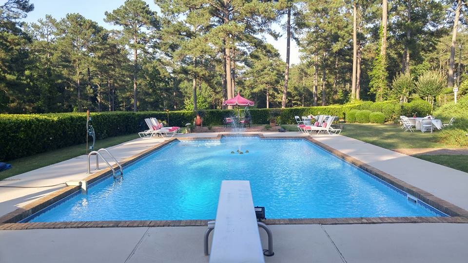 Großes Shabby-Look Sportbecken hinter dem Haus in rechteckiger Form mit Wasserspiel und Betonboden in Atlanta