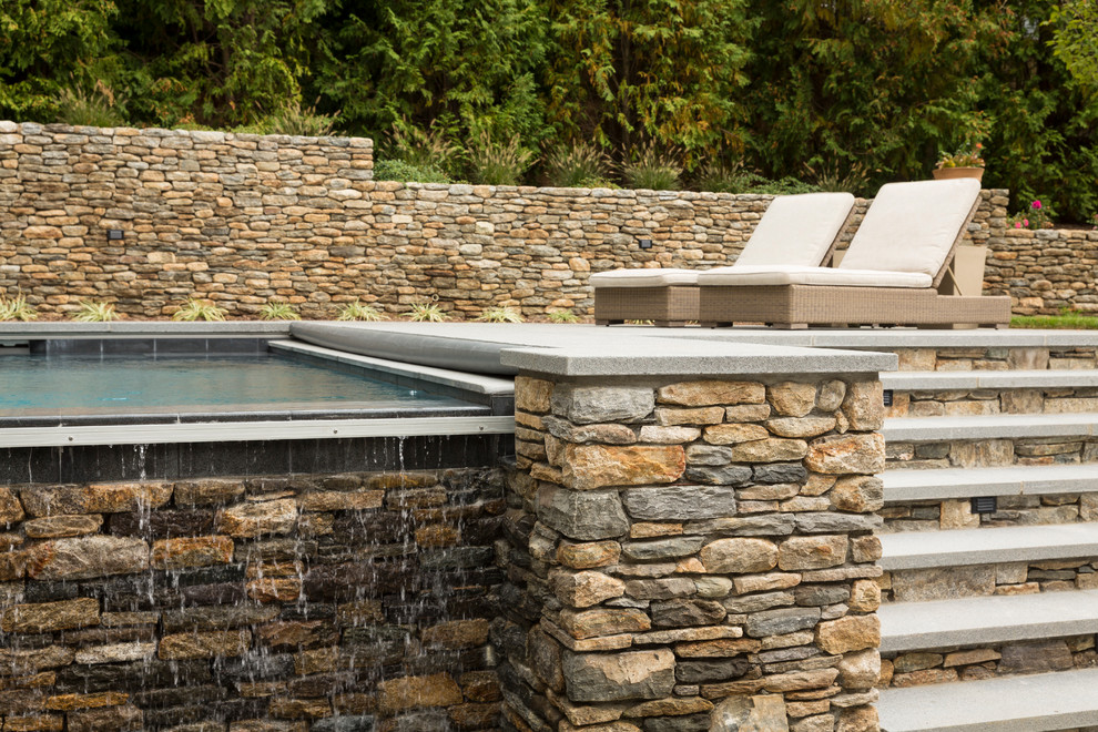 Idées déco pour une grande piscine à débordement et arrière contemporaine rectangle avec un bain bouillonnant et une terrasse en bois.
