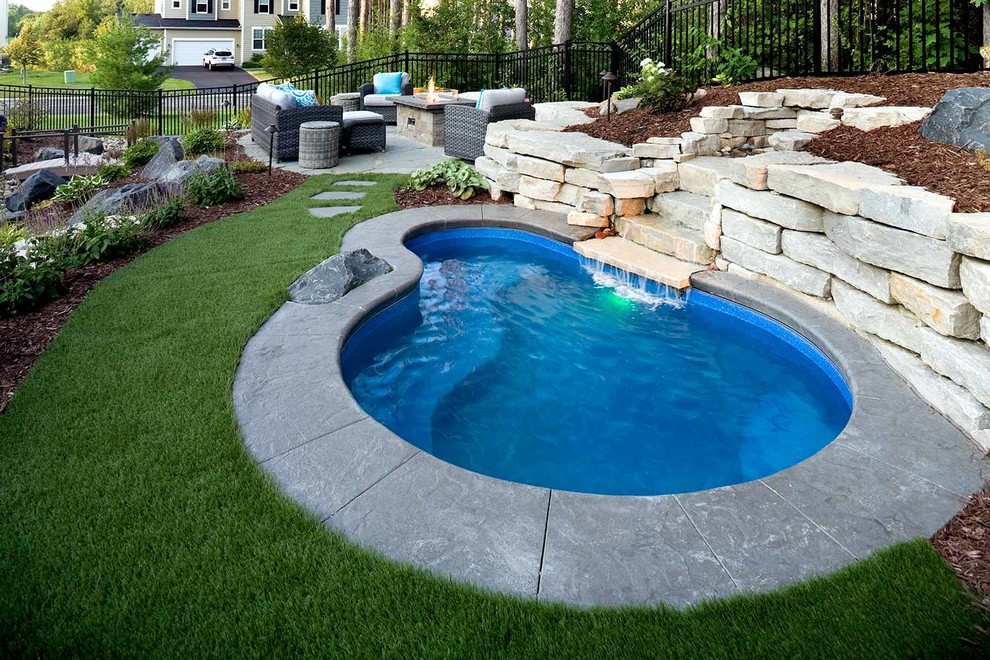 Стильный дизайн: большой бассейн в форме фасоли на заднем дворе - последний тренд